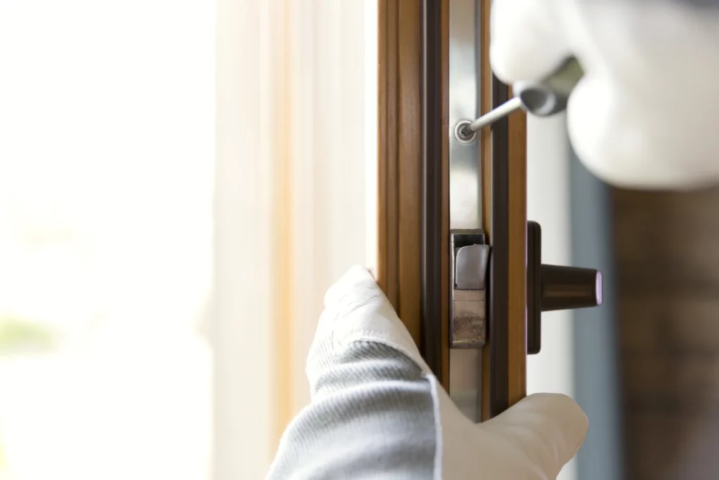 Gloved hand fitting a handle to a wood-effect door