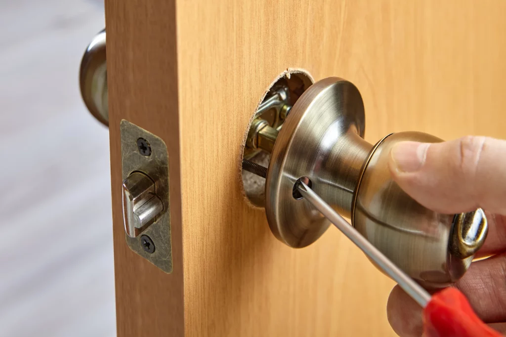 Screwdriver tightening a door handle and lock