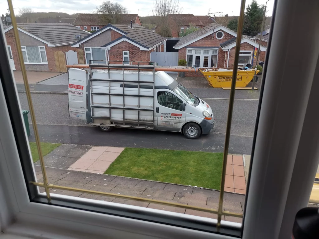 The Window Restore van parked outside a customer's home, seen through a window